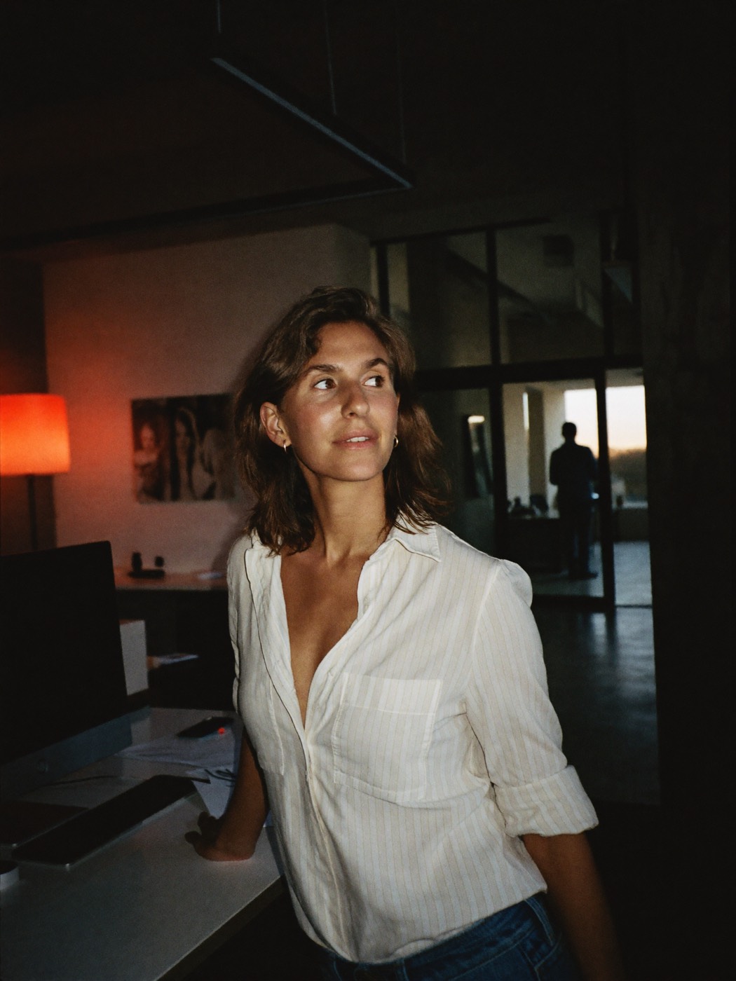 A marketer in a dark office at dusk, red lamp glowing, working with numbers she can finally trust